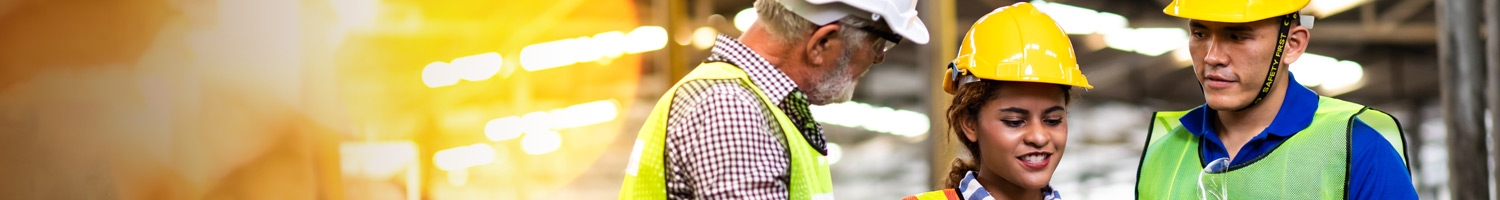 Three professionals in industrial gear at a work or construction site