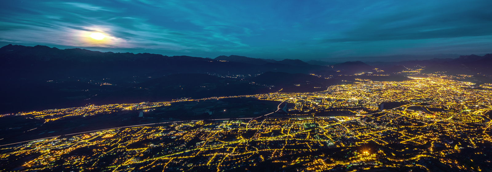 Valley city at night under moonlight, symbolizing reliable energy through GE Vernova grid solutions
